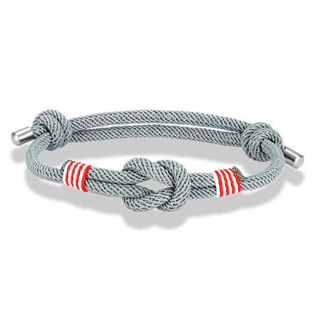 Bracelet nautique homme au cordage gris avec nœud marin central, surliures rouges doublées de blanc et embouts en acier poli