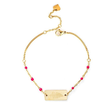 Bracelet doré fantaisie avec plaque rectangulaire gravée d'une fougère et accompagné de perles rose vif